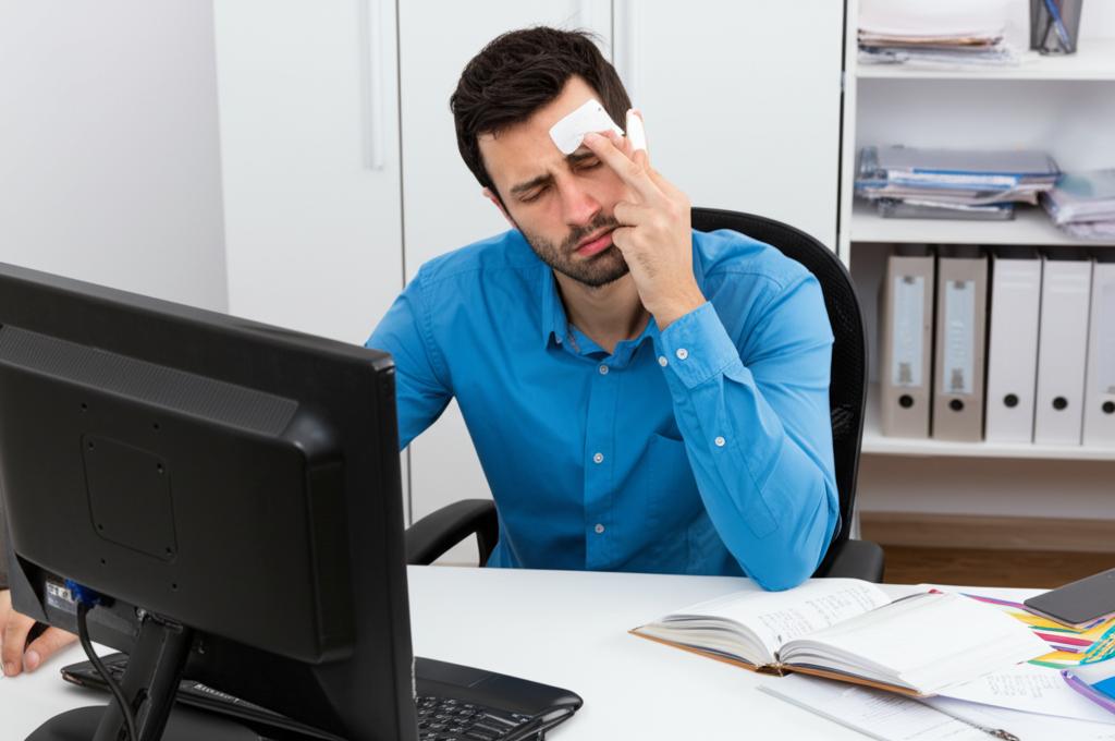 Man looking tired and stressed at office desk