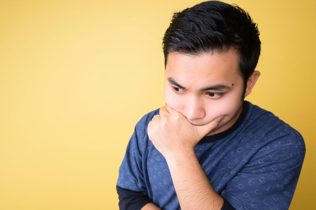 A man looking thoughtful or slightly worried, contemplating concerns about performance. Calm, relatable style.